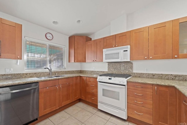 kitchen featuring sink, light tile patterned floors, light stone counters, and white appliances