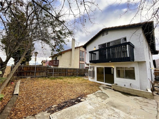 rear view of house featuring a balcony and a patio