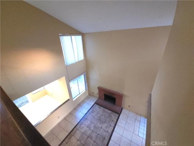 unfurnished living room featuring light tile patterned floors and high vaulted ceiling