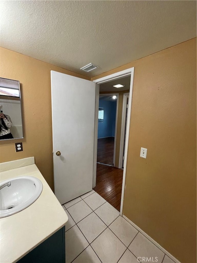 bathroom with vanity, tile patterned floors, and a textured ceiling