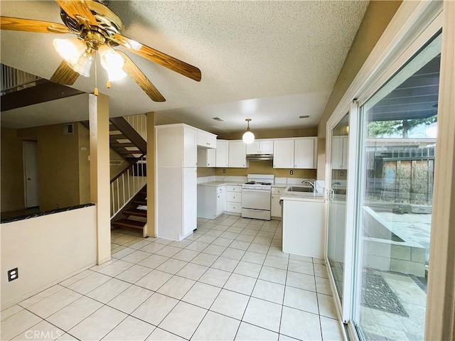 kitchen featuring sink, white cabinets, light tile patterned floors, gas range gas stove, and a textured ceiling