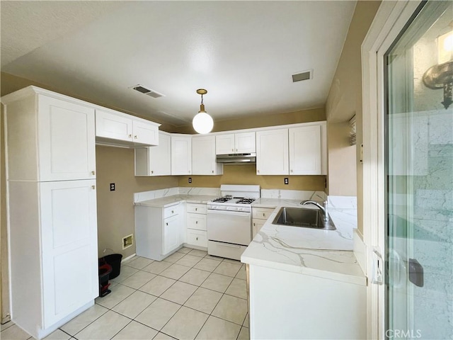 kitchen featuring light stone counters, sink, white gas range oven, and white cabinets