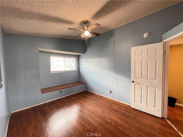 spare room with ceiling fan, dark hardwood / wood-style flooring, and a textured ceiling