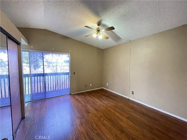 unfurnished room featuring a textured ceiling, vaulted ceiling, dark hardwood / wood-style floors, and ceiling fan