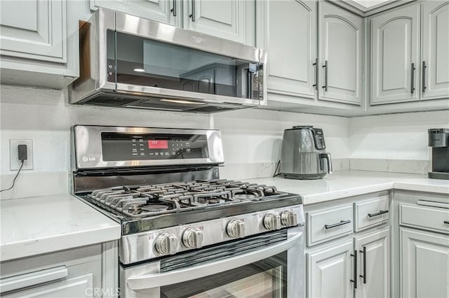 kitchen with light stone counters and stainless steel appliances