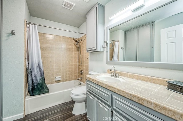 full bathroom with vanity, hardwood / wood-style floors, shower / bath combination with curtain, and toilet