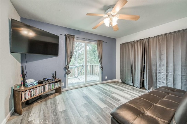 living area with ceiling fan and light hardwood / wood-style flooring