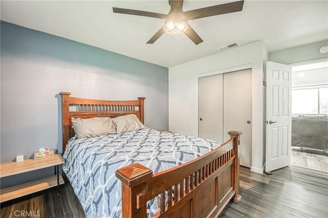 bedroom with dark wood-type flooring, ceiling fan, and a closet