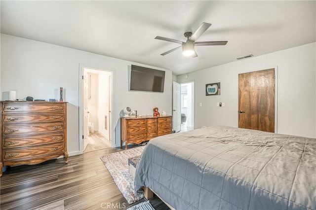 bedroom with wood-type flooring, connected bathroom, and ceiling fan