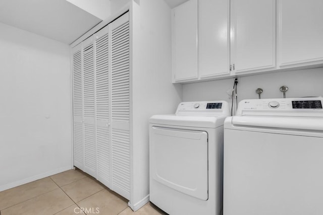 laundry area featuring cabinets, independent washer and dryer, and light tile patterned flooring