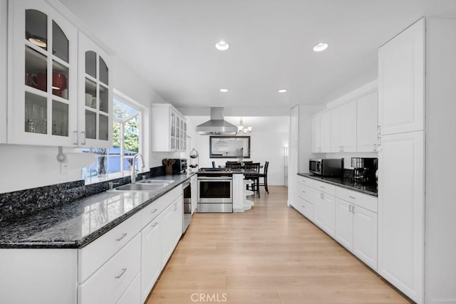 kitchen with white cabinetry, sink, island exhaust hood, and appliances with stainless steel finishes