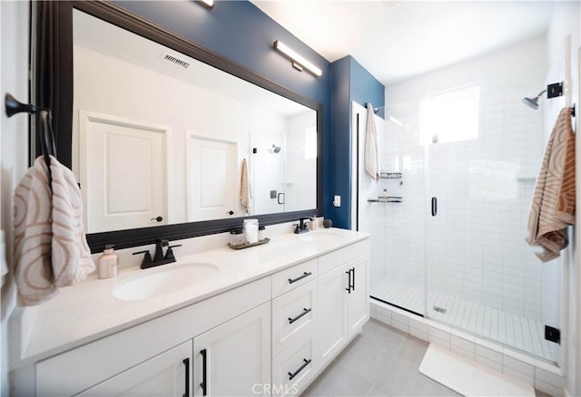 bathroom with tile patterned flooring, vanity, and a shower with door