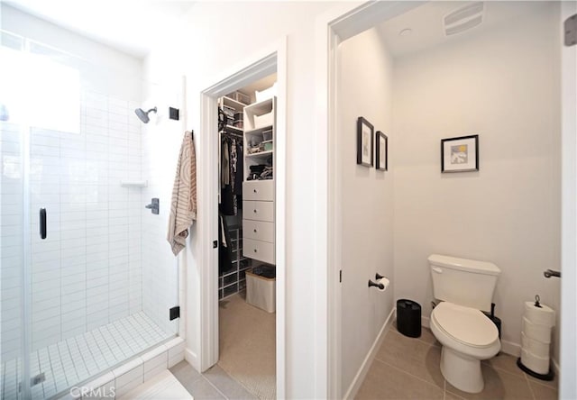 bathroom featuring walk in shower, toilet, and tile patterned flooring