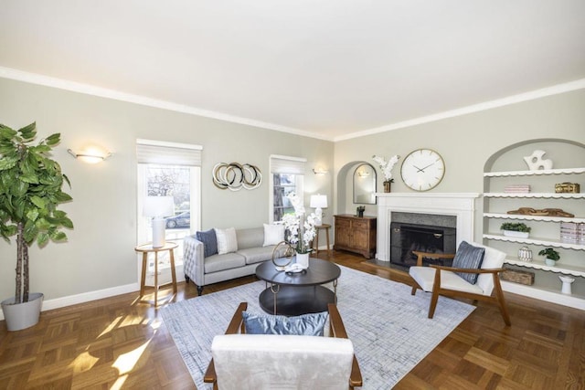 living room featuring ornamental molding, dark parquet floors, and a high end fireplace