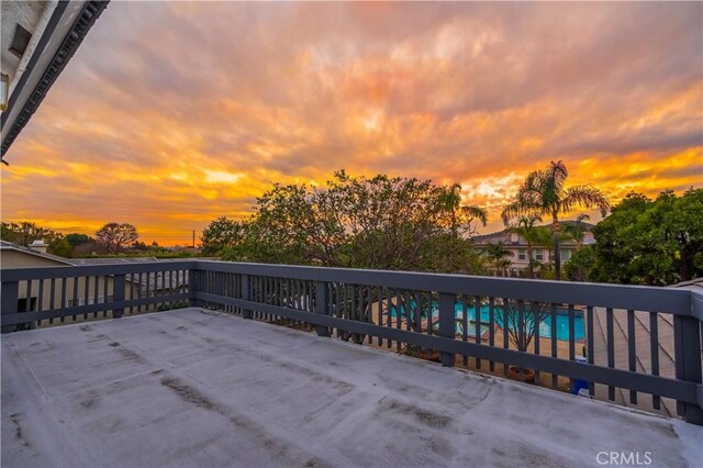 patio terrace at dusk featuring a pool