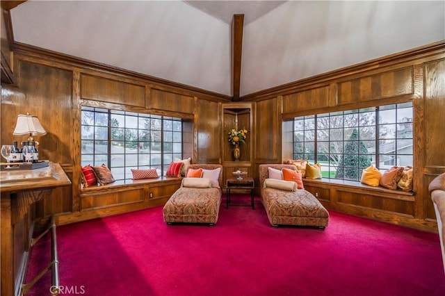 living area featuring high vaulted ceiling, wooden walls, carpet floors, and beam ceiling