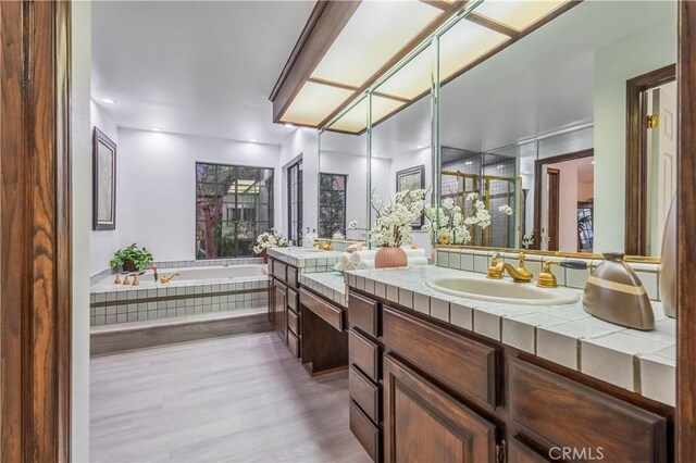 bathroom featuring double vanity, a sink, and a bath