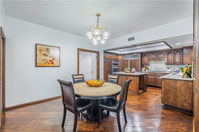 dining room featuring dark wood-type flooring and a notable chandelier