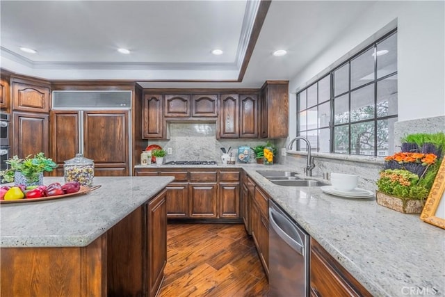 kitchen with appliances with stainless steel finishes, dark hardwood / wood-style floors, sink, backsplash, and light stone counters