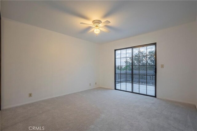 carpeted spare room with ceiling fan