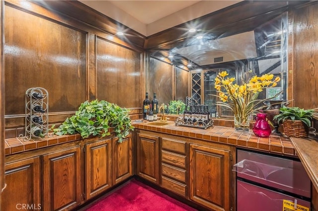 interior space featuring tile countertops, sink, and dark colored carpet