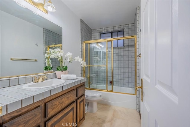 full bathroom with vanity, tile patterned floors, combined bath / shower with glass door, and toilet