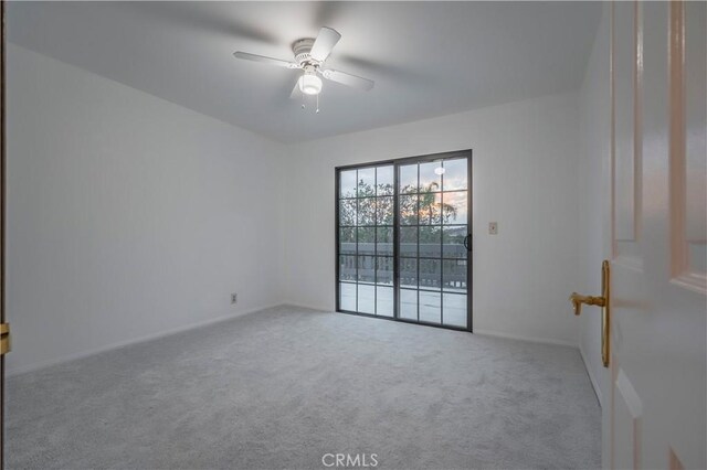 carpeted spare room featuring ceiling fan