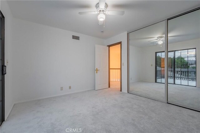 unfurnished bedroom featuring ceiling fan, access to outside, carpet floors, and visible vents