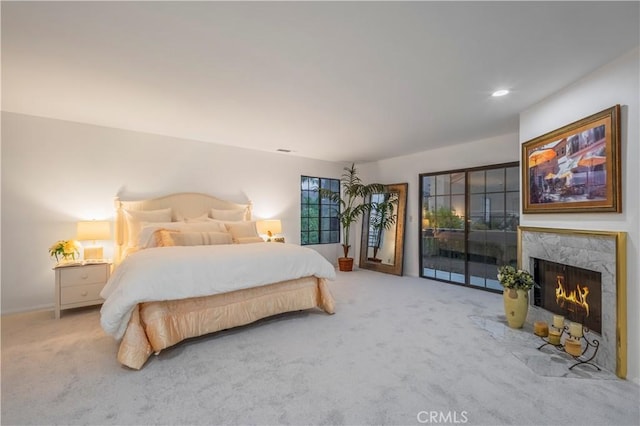 bedroom featuring carpet floors, access to outside, and a fireplace