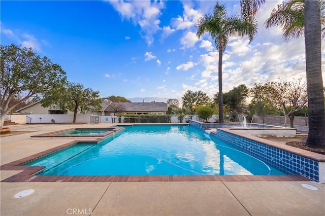 view of swimming pool featuring an in ground hot tub