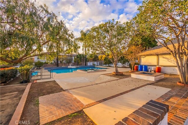 outdoor pool with a fire pit and a patio area