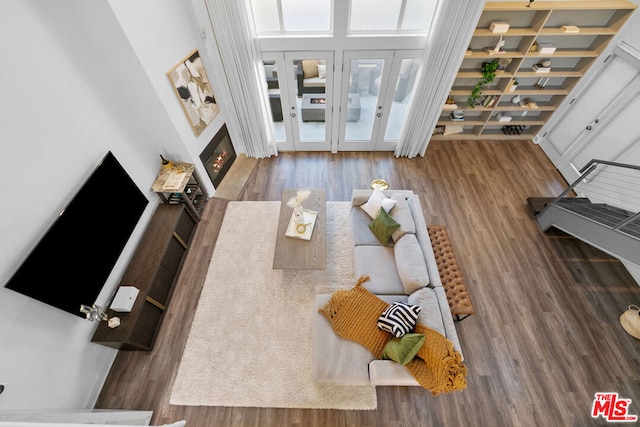 living room featuring a high ceiling and wood-type flooring