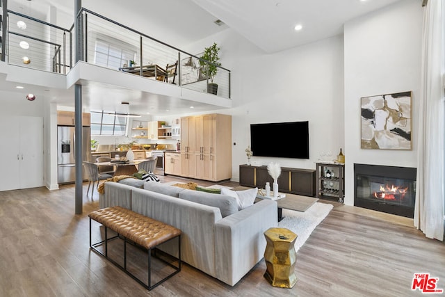 living room with a towering ceiling and light hardwood / wood-style floors