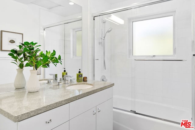 bathroom featuring vanity and combined bath / shower with glass door