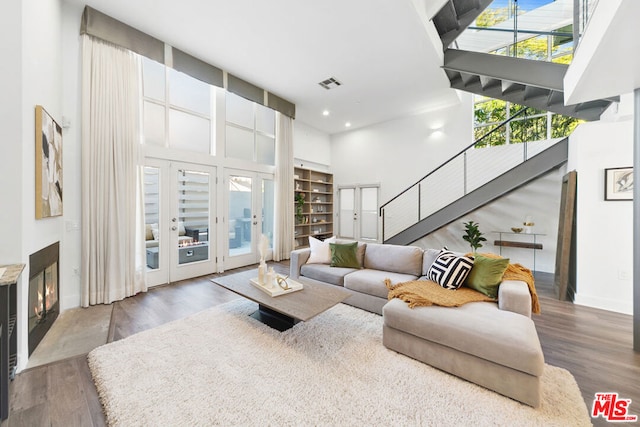 living room featuring hardwood / wood-style flooring and a towering ceiling