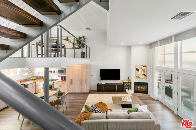 living room featuring hardwood / wood-style flooring and a high ceiling