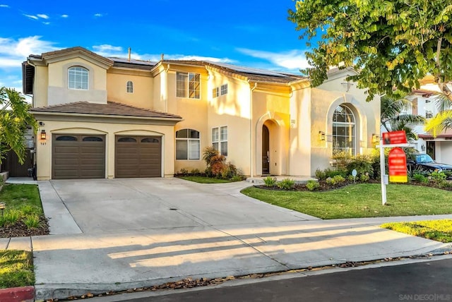 mediterranean / spanish-style home with a garage and a front yard