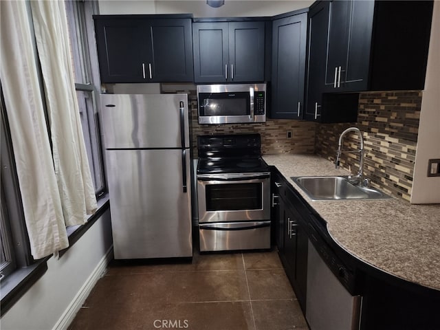 kitchen featuring stainless steel appliances, sink, dark tile patterned flooring, and decorative backsplash