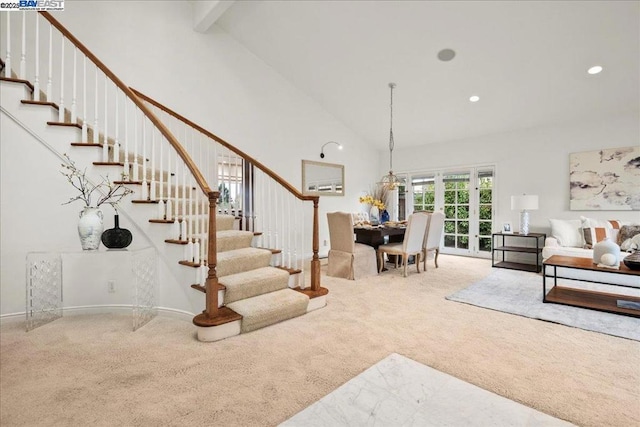 carpeted living room featuring high vaulted ceiling