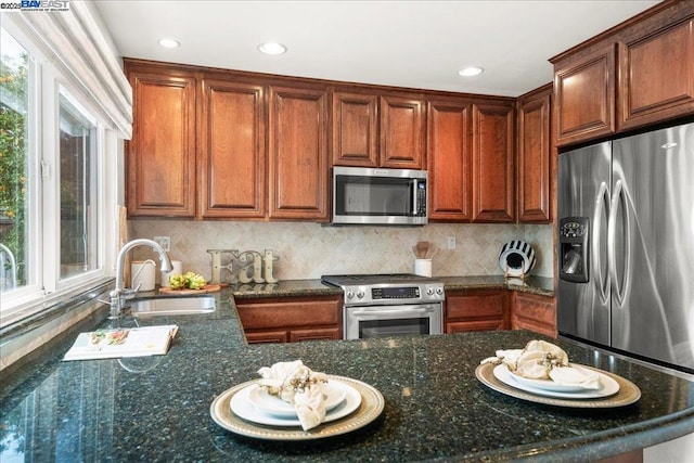 kitchen with sink, backsplash, stainless steel appliances, and a healthy amount of sunlight