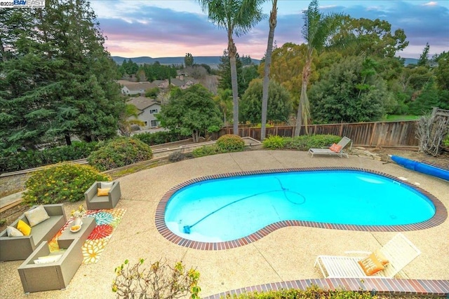 pool at dusk with a patio