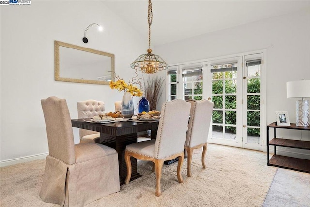 carpeted dining area featuring vaulted ceiling