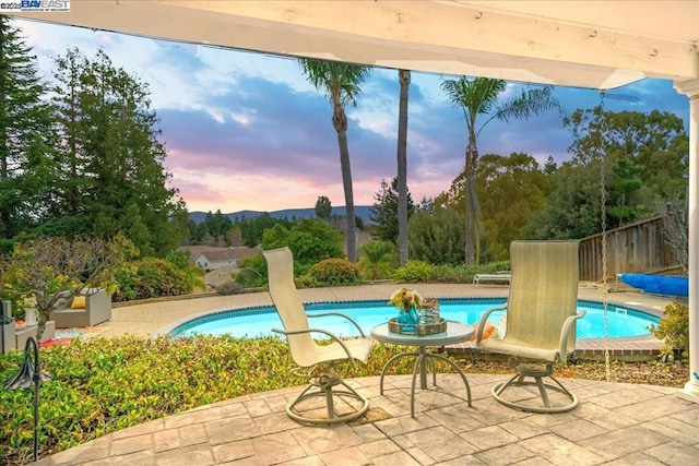 pool at dusk with a patio