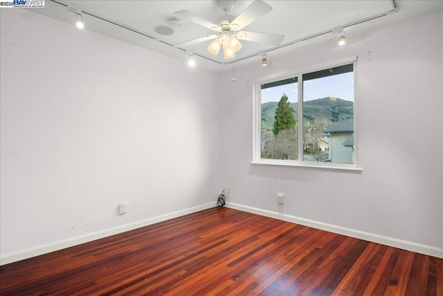 spare room with ceiling fan, track lighting, and hardwood / wood-style floors