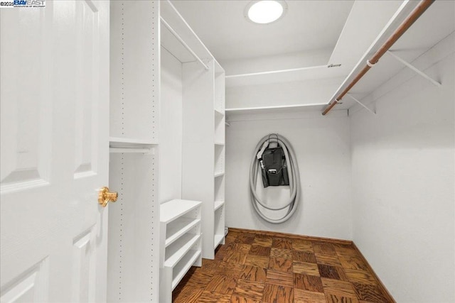 spacious closet featuring dark parquet floors