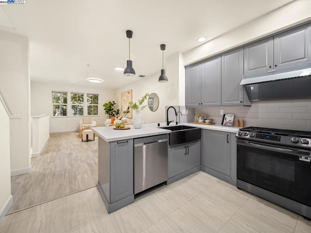 kitchen with gray cabinetry, sink, stainless steel appliances, and kitchen peninsula