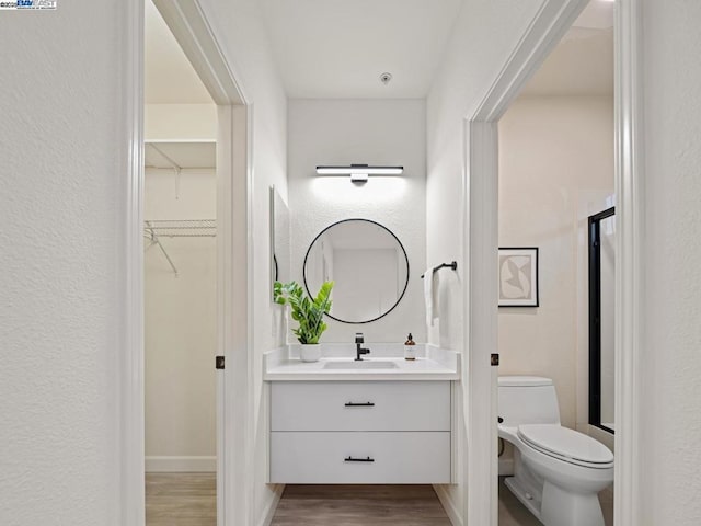 bathroom with vanity, hardwood / wood-style flooring, and toilet