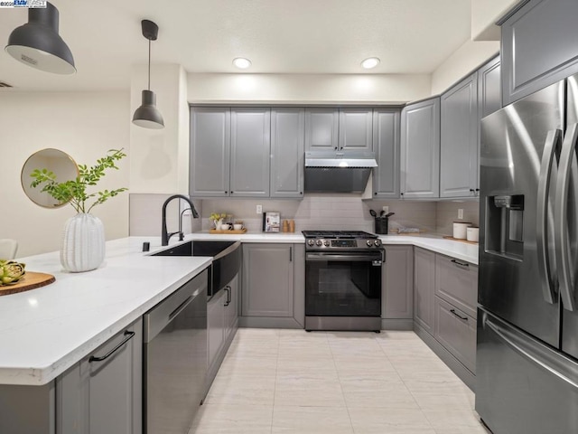 kitchen with sink, gray cabinets, appliances with stainless steel finishes, decorative light fixtures, and kitchen peninsula