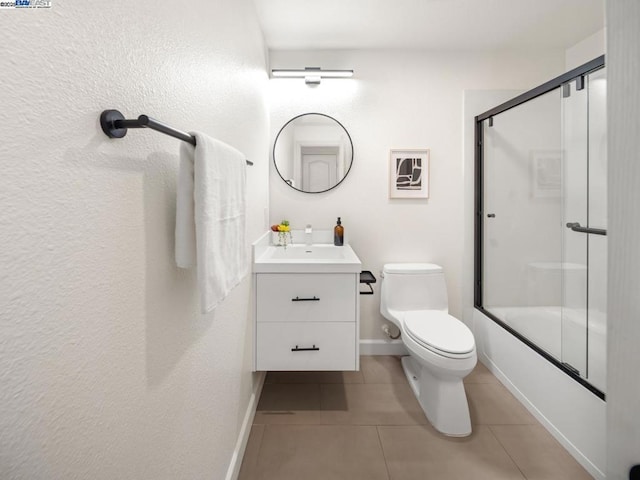 full bathroom with tile patterned flooring, enclosed tub / shower combo, vanity, and toilet