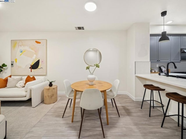 dining area with sink and light hardwood / wood-style flooring